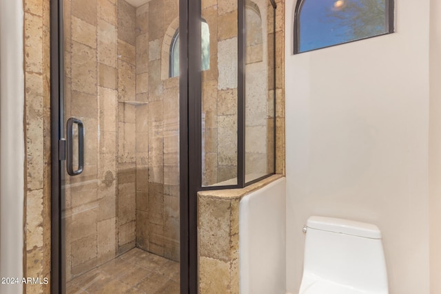 full bathroom featuring a stall shower and toilet