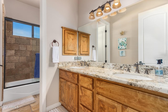 bathroom with double vanity, a sink, and shower / bath combination with glass door