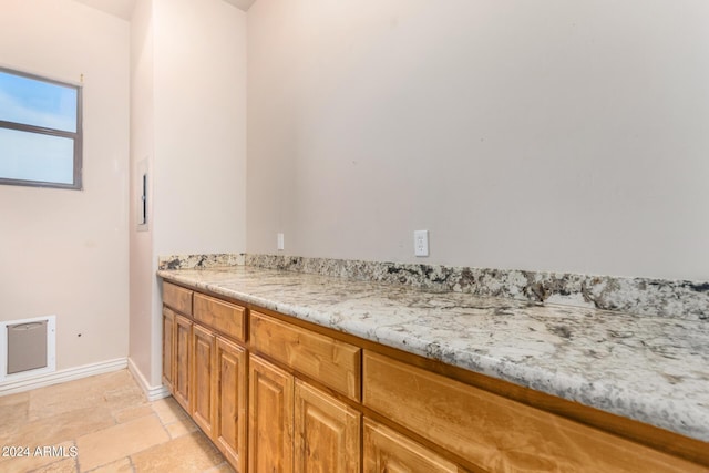 bathroom with baseboards and stone tile flooring