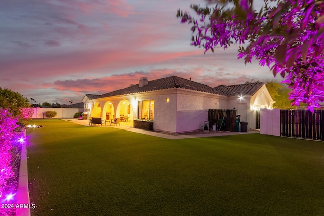 back of property with a chimney, a tile roof, a patio area, a fenced backyard, and stucco siding