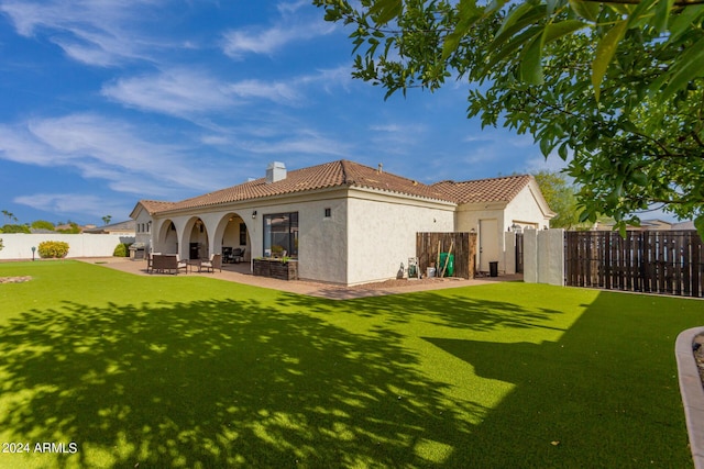 back of house featuring a patio, a fenced backyard, stucco siding, a chimney, and a tiled roof