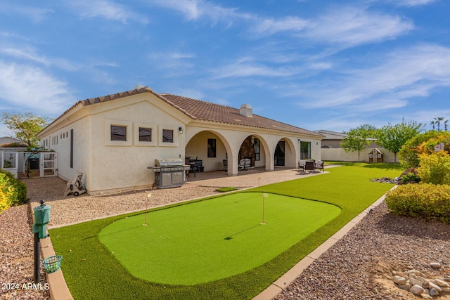 back of house with fence, stucco siding, a chimney, a patio, and a tiled roof