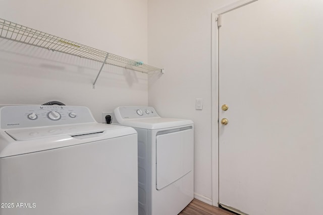 washroom featuring washing machine and clothes dryer, laundry area, and wood finished floors
