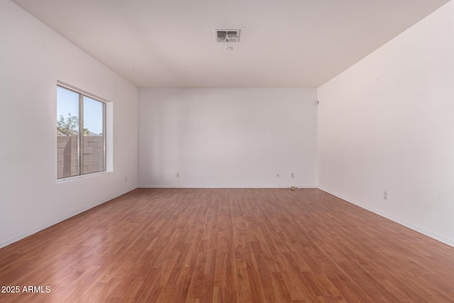 spare room with visible vents, light wood-style flooring, and baseboards