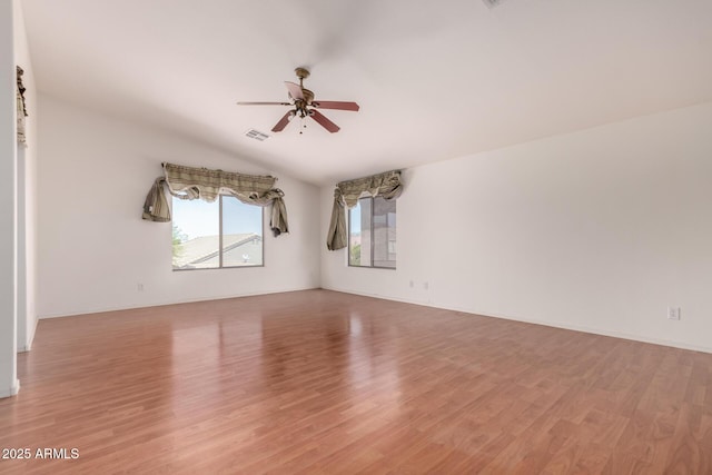 empty room featuring visible vents, light wood-style floors, ceiling fan, and vaulted ceiling