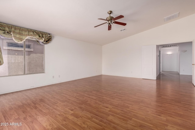 unfurnished room featuring visible vents, a ceiling fan, wood finished floors, and vaulted ceiling