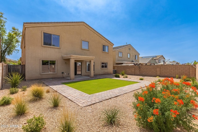 back of house featuring a patio, a fenced backyard, stucco siding, and a yard
