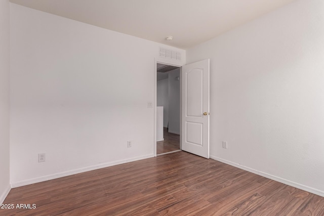 unfurnished room featuring baseboards and wood finished floors