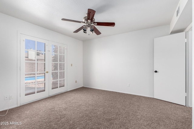 carpeted spare room with baseboards, french doors, visible vents, and a ceiling fan