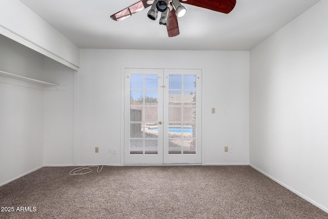 carpeted empty room with baseboards and a ceiling fan