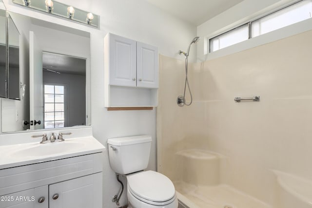 bathroom featuring a shower, vanity, and toilet