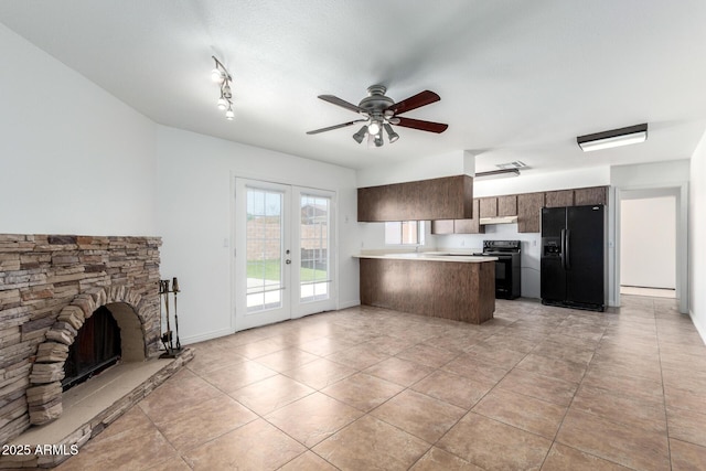 kitchen featuring a peninsula, french doors, light countertops, under cabinet range hood, and black appliances