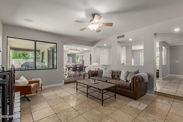 6417 E Kings Ave, Scottsdale, AZ 85254 - living area with stone tile floors, a ceiling fan, and a chandelier