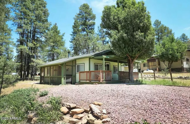 view of front of property with a porch and fence