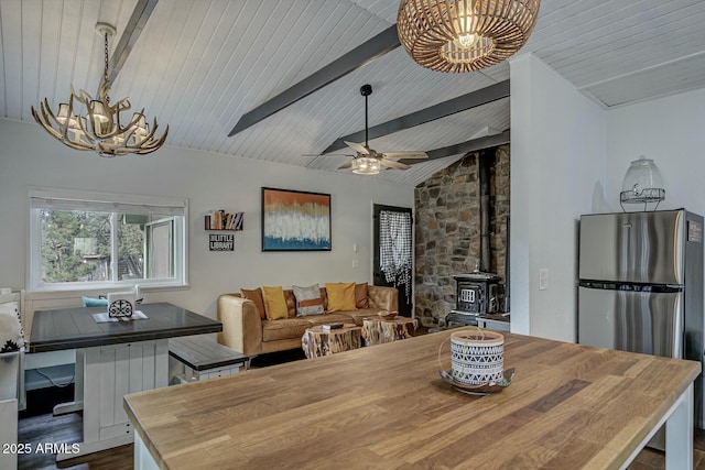 dining room featuring wood ceiling, a wood stove, lofted ceiling with beams, and ceiling fan with notable chandelier