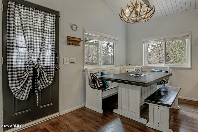 home office featuring lofted ceiling, an inviting chandelier, baseboards, and dark wood finished floors