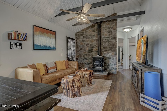 living room with a ceiling fan, lofted ceiling with beams, dark wood-style floors, wooden ceiling, and a wood stove