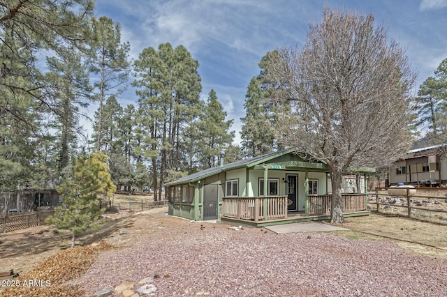 view of front of property featuring fence and a sunroom