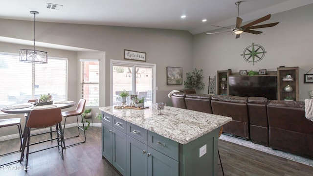 kitchen with pendant lighting, dark hardwood / wood-style flooring, a kitchen island, and lofted ceiling