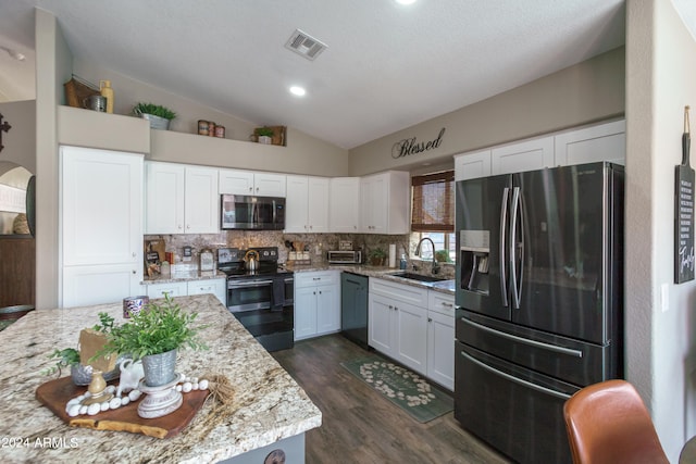 kitchen featuring light stone countertops, sink, black appliances, and lofted ceiling