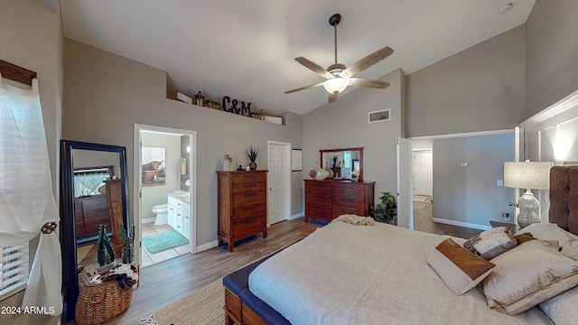 bedroom with wood-type flooring, high vaulted ceiling, ensuite bath, and ceiling fan