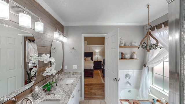 bathroom with a washtub, hardwood / wood-style floors, vanity, and ornamental molding