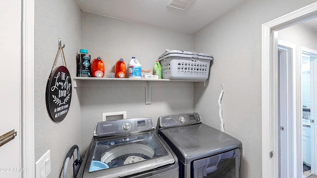 laundry room featuring separate washer and dryer and a textured ceiling