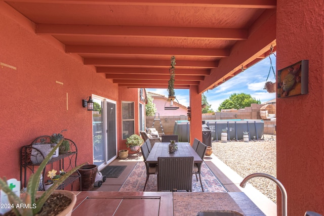 view of patio featuring a fenced in pool and sink