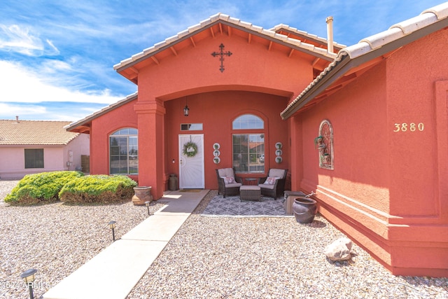 entrance to property featuring a patio area and an outdoor living space