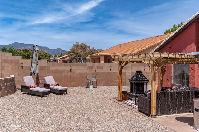 view of yard featuring a mountain view, a pergola, and a patio