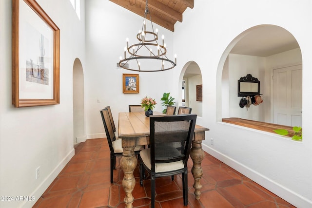 tiled dining area with lofted ceiling with beams and an inviting chandelier