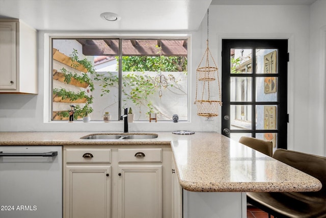 kitchen with a healthy amount of sunlight, white cabinets, and stainless steel dishwasher