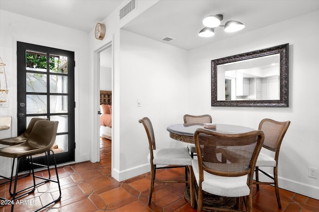 dining space featuring dark tile patterned flooring