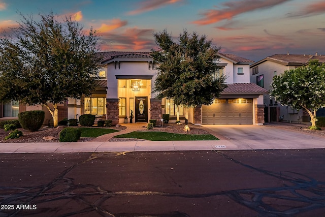 view of front of house featuring driveway, stone siding, a tile roof, and stucco siding