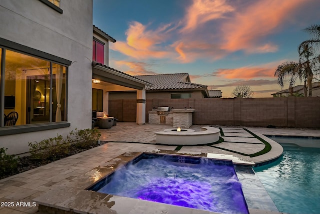 view of swimming pool with a fenced in pool, grilling area, fence, exterior kitchen, and a patio area