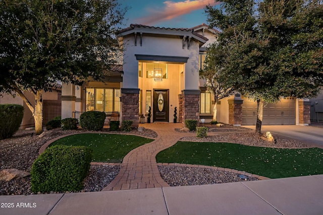 view of front of home featuring stone siding, concrete driveway, and stucco siding