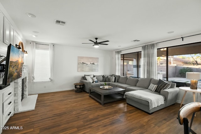 living area featuring dark wood-style floors, visible vents, and baseboards