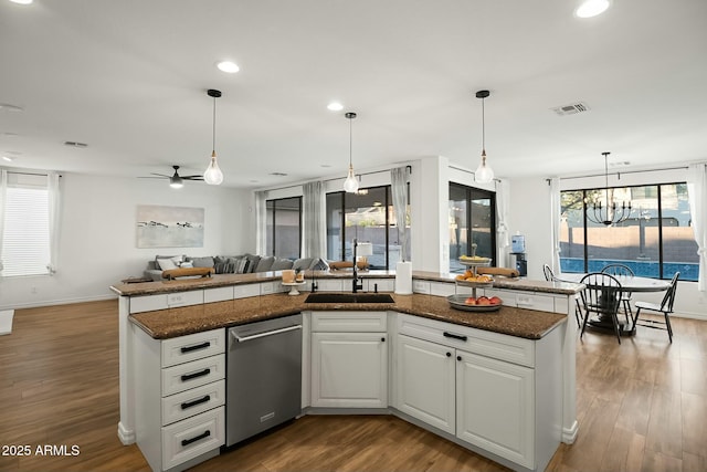 kitchen with visible vents, dark wood-type flooring, open floor plan, a sink, and dishwasher