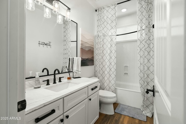 bathroom with toilet, shower / bathtub combination with curtain, wood finished floors, and vanity