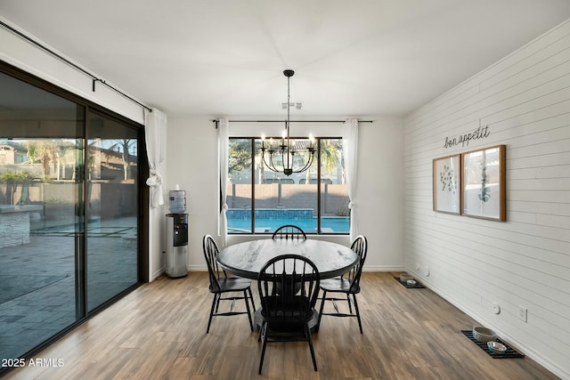 dining room featuring a chandelier, visible vents, baseboards, and wood finished floors