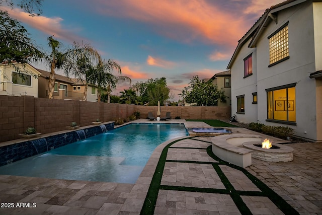 view of pool with a fire pit, a fenced in pool, a patio, a fenced backyard, and an in ground hot tub