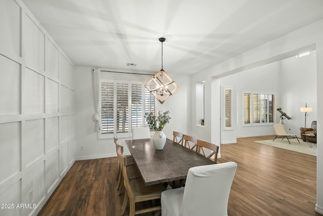 dining area featuring dark wood-style floors, a chandelier, visible vents, and baseboards