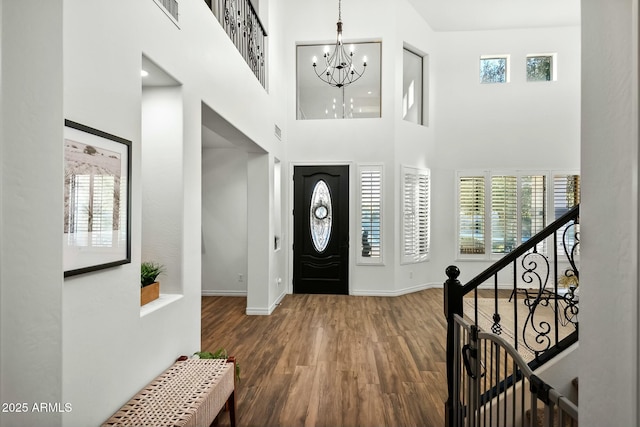 foyer with a chandelier, wood finished floors, and a healthy amount of sunlight