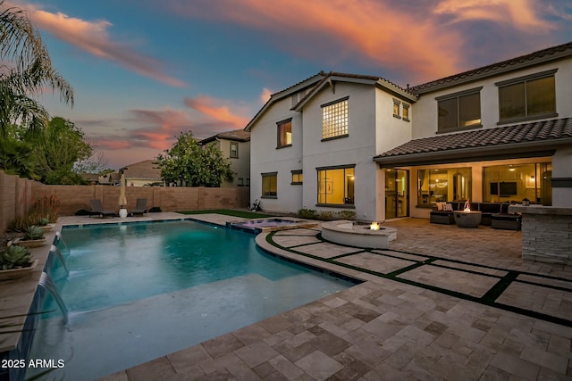 back of house with stucco siding, a fenced backyard, a patio, and an outdoor hangout area