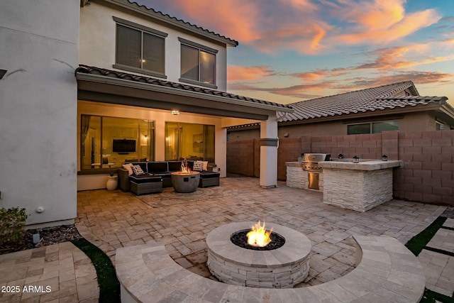 view of patio featuring an outdoor living space with a fire pit, fence, and area for grilling