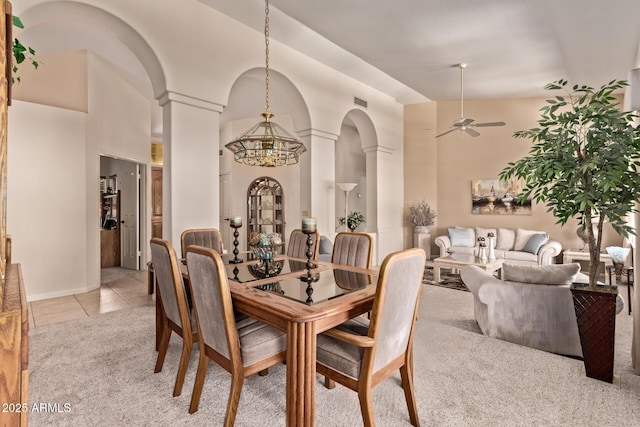 7648 W Mauna Loa Ln, Peoria, AZ 85381 - dining space with decorative columns, light carpet, a chandelier, arched walkways, and ceiling fan