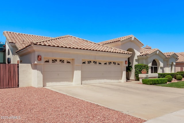 7648 W Mauna Loa Ln, Peoria, AZ 85381 - mediterranean / spanish home featuring a garage, driveway, a tile roof, stucco siding, and fence