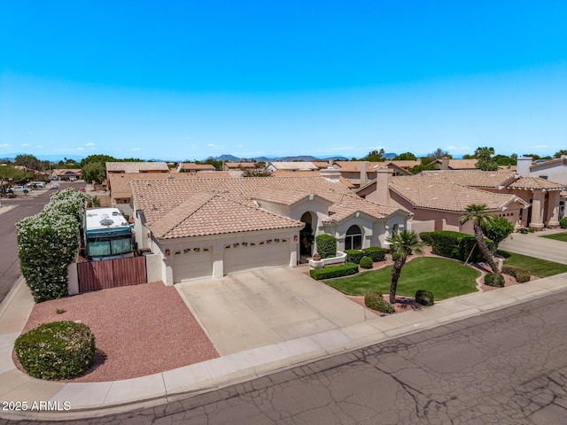 7648 W Mauna Loa Ln, Peoria, AZ 85381 - mediterranean / spanish-style home with an attached garage, stucco siding, concrete driveway, a tile roof, and a residential view