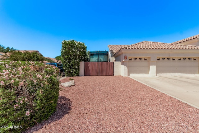 7648 W Mauna Loa Ln, Peoria, AZ 85381 - view of front facade featuring an attached garage, driveway, a tile roof, stucco siding, and fence