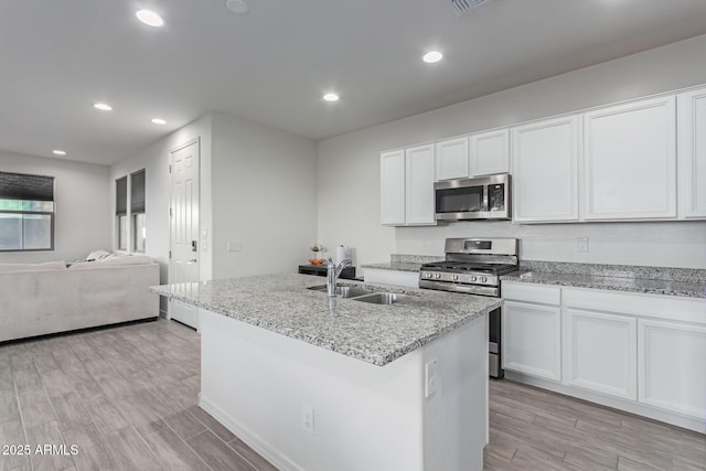 3714 S 58th Dr, Phoenix, AZ 85043 - kitchen featuring appliances with stainless steel finishes, a sink, open floor plan, light stone countertops, and recessed lighting